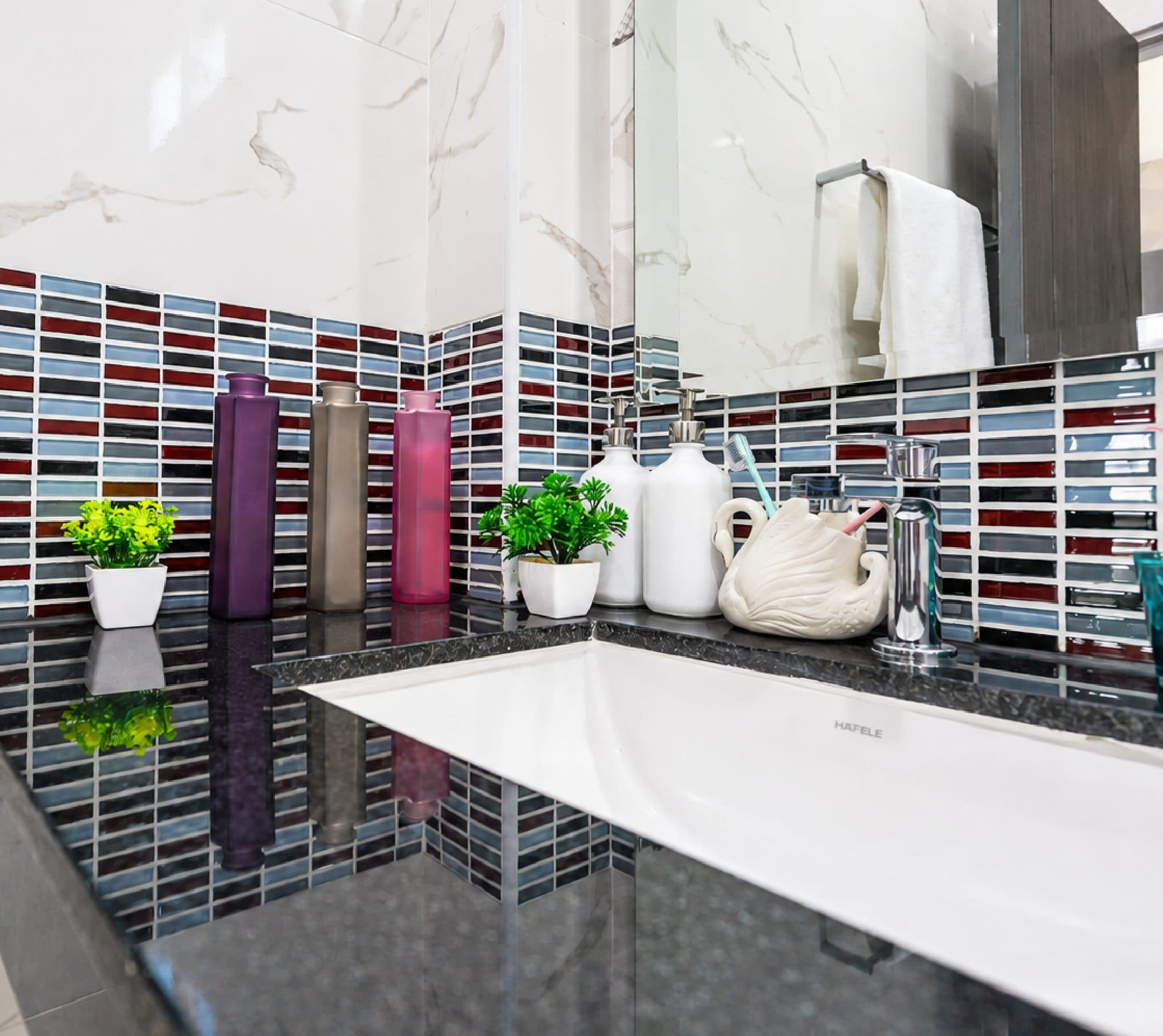 Bathtub with mosaic tile and a granite surround.