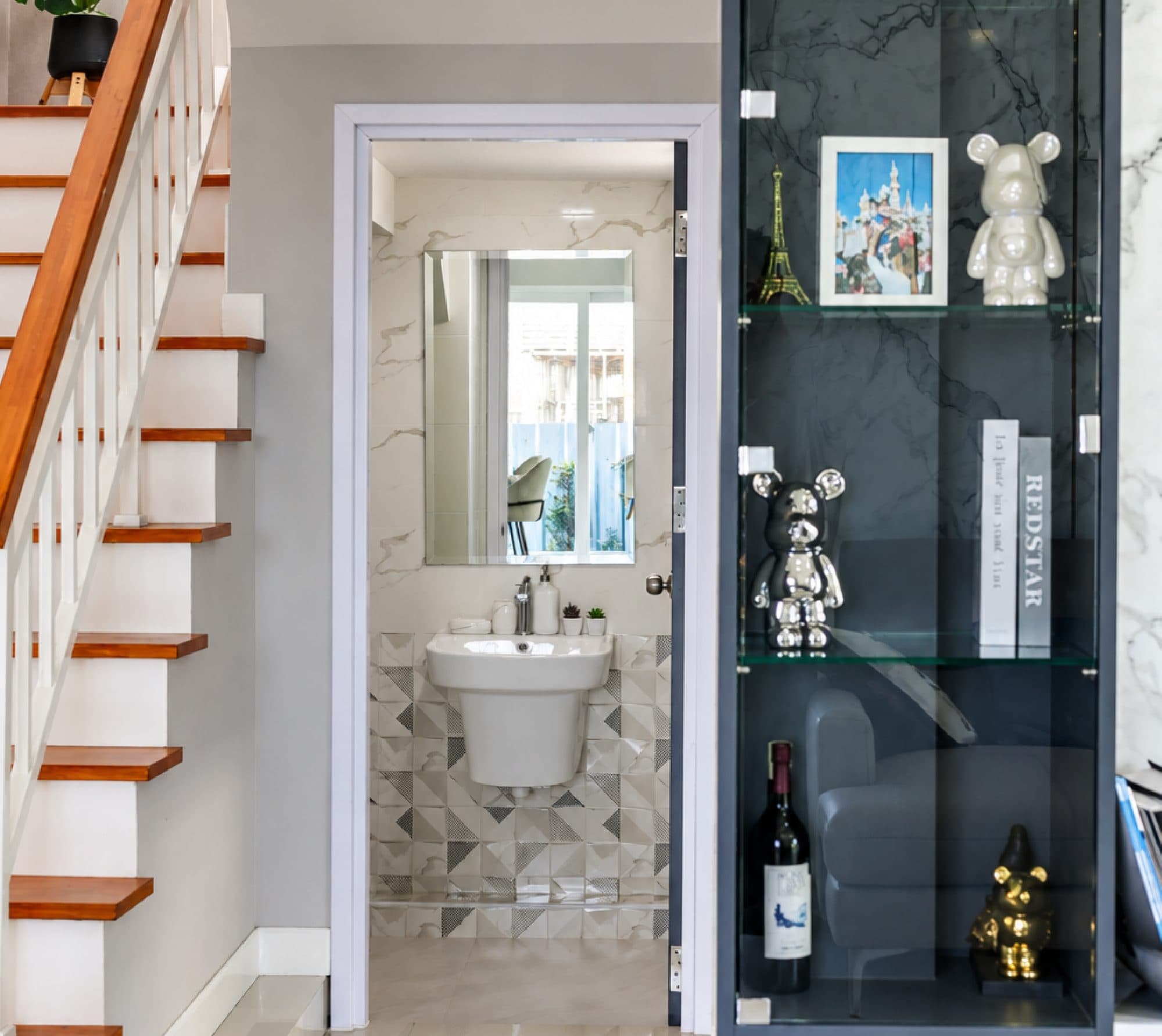 Timber stair treads, the ground-floor washroom and a glass display cabinet.