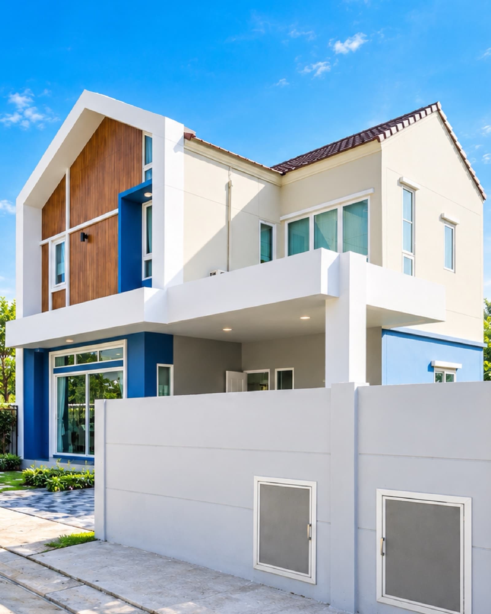 บ้านเดี่ยว 2 ชั้น The Trend หทัยราษฎร์ หน้าจั่วกรุไม้ ผนังสีขาวและน้ำเงิน หลังรั้วสีขาว