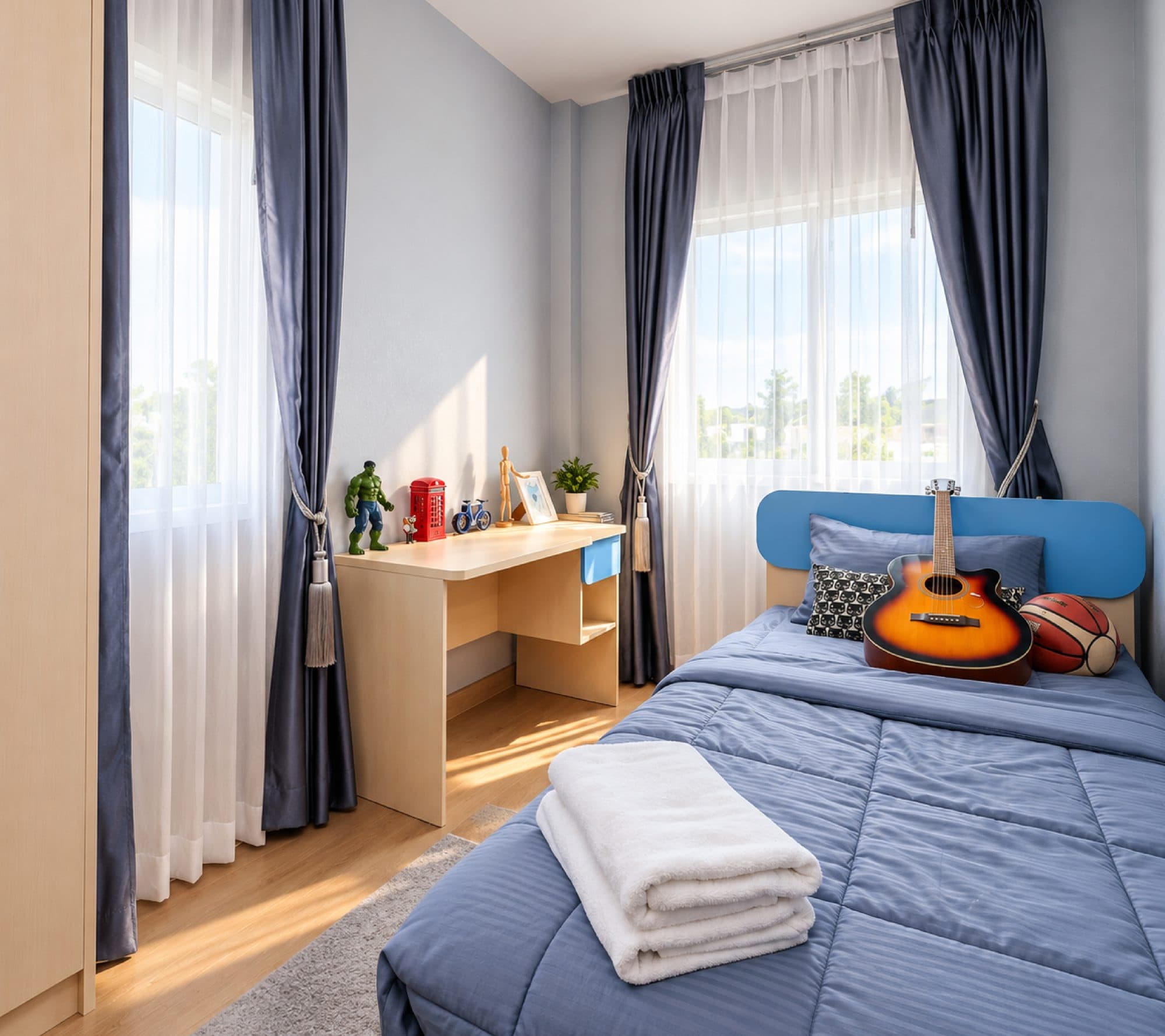 Bedroom with blue bedding and a desk by the window.
