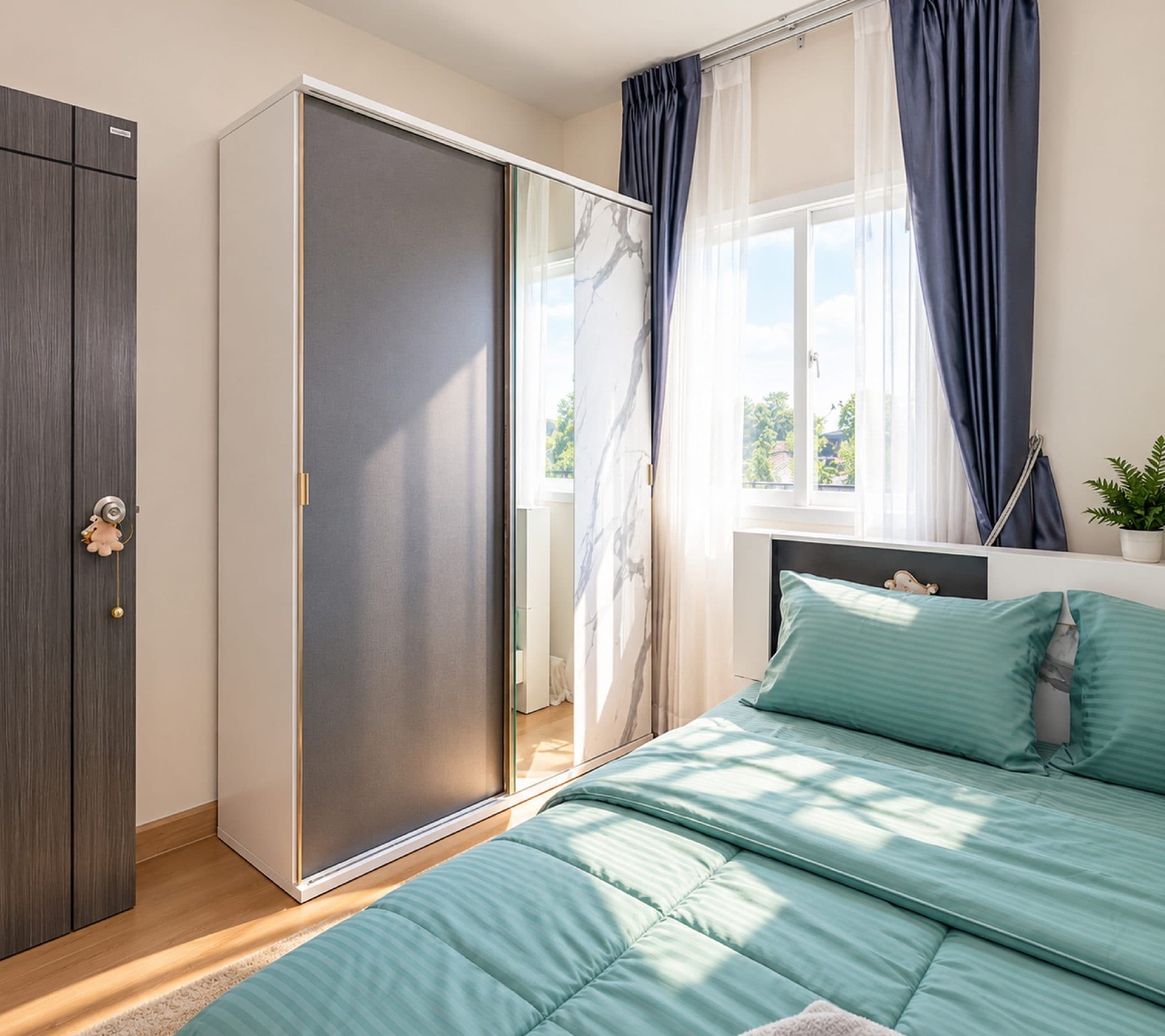 Bedroom with mint bedding and a sliding wardrobe.